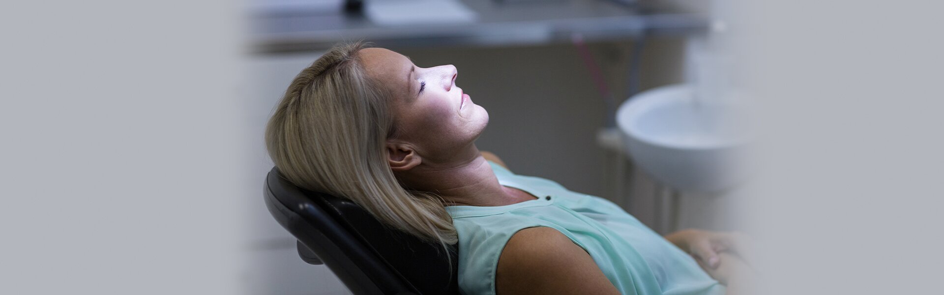 dentist patient model in a dental chair with her eyes closed