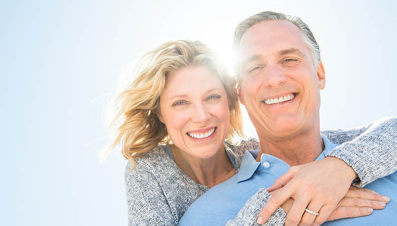 dentist patient model pointing to her smile